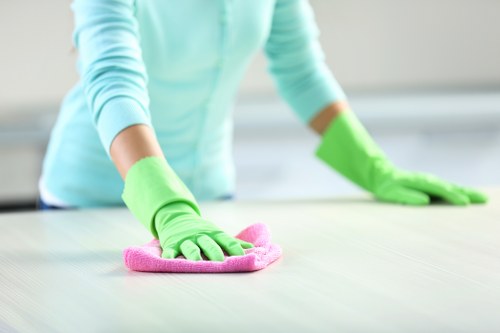 Cleaner wearing PPE while operating professional carpet cleaning machinery